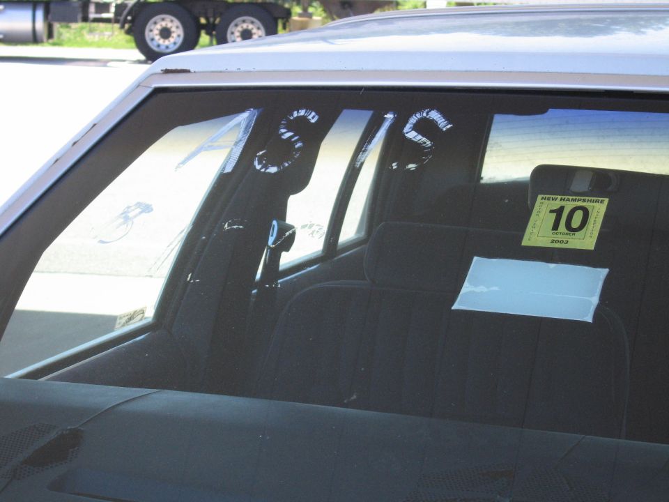 Sedan rear window painted AS IS with New Hampshire October 2003 inspection sticker