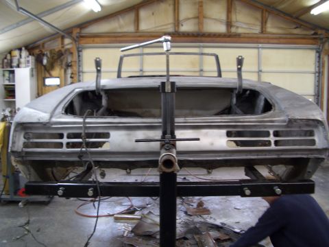 1967 Pontiac GTO - The rear end of a 1967 Pontiac GTO is shown while being worked on in a garage, supported by a restoration lift.