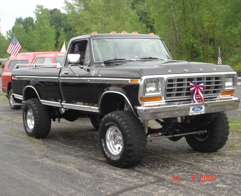 1979 Ford F-250 - Lifted 1979 Ford F-250 pickup truck with patriotic decorations and large off-road tires.
