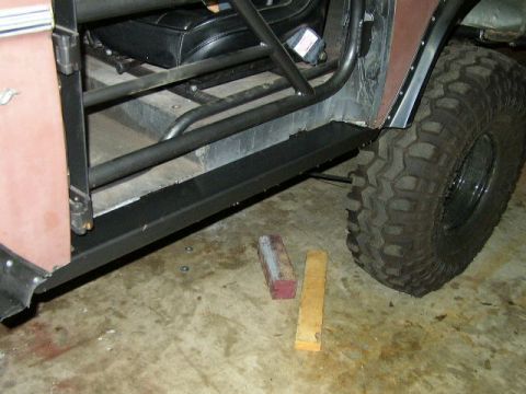 1995 Ford Bronco - Close-up of the side of a 1995 Ford Bronco, highlighting its interior roll cage and custom sliders.