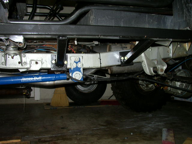 Underbody of a vehicle with a blue shock absorber labeled 'James Duff'