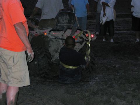1985 Ford Bronco - People attempt to free an ATV that is deeply stuck in mud.