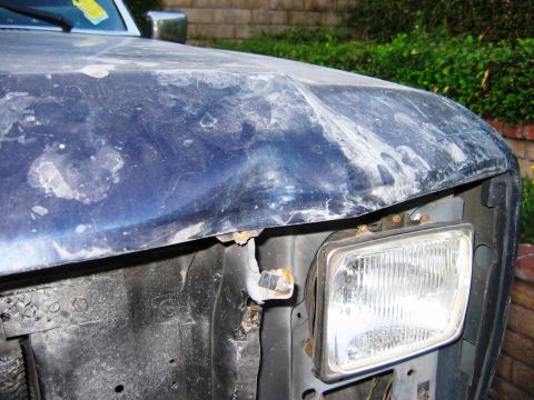 1985 Ford Bronco - The front corner of the vehicle shows significant damage to the hood and fender area.