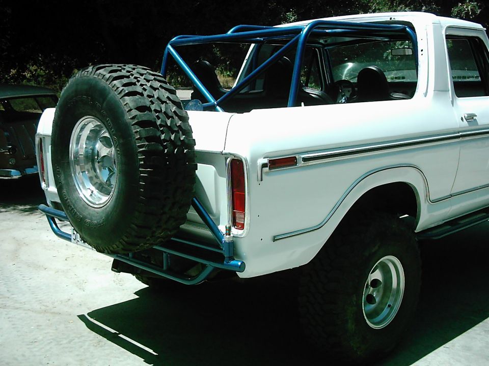 1978 Ford Bronco rear view with external spare tire carrier and blue roll cage