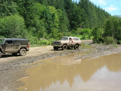 1989 Dodge Power Ram - A tan 1988 Dodge Ramcharger navigates a muddy trail, with another SUV visible in the background.