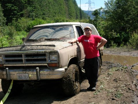 1989 Dodge Power Ram - Muddy 1989 Dodge Power Ram stuck in a mire with a man posing beside it.