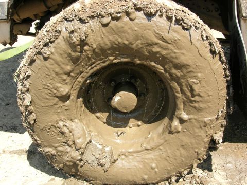 1989 Dodge Power Ram - A close-up view of a vehicle's tire heavily coated in thick mud.