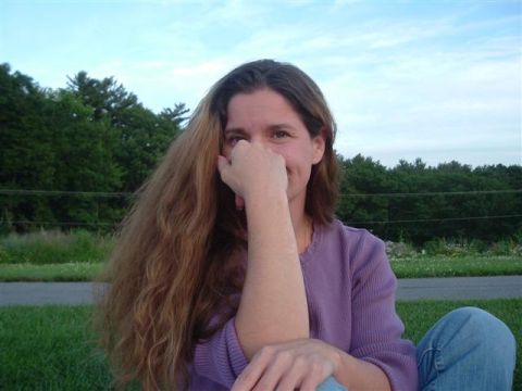 1990 Toyota Celica - Woman sits outdoors with her hand covering her mouth and nose, long hair falling forward.