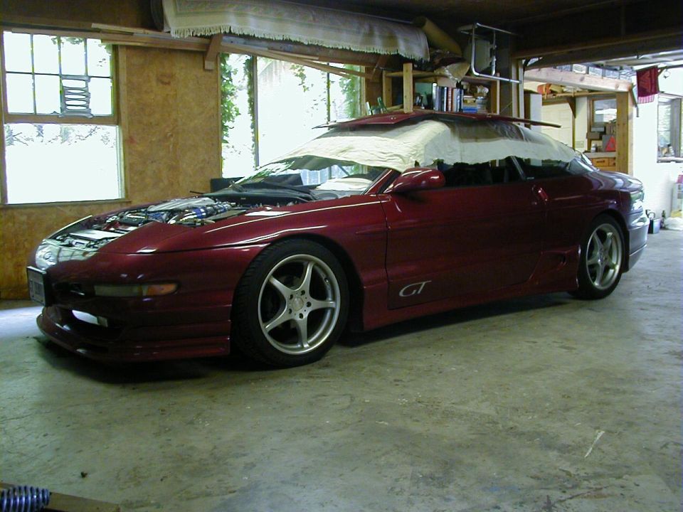 maroon Ford Probe GT with hood open, parked inside a garage