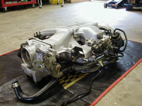 1994 Ford Probe - An engine intake manifold assembly is shown on a mat in a garage setting.