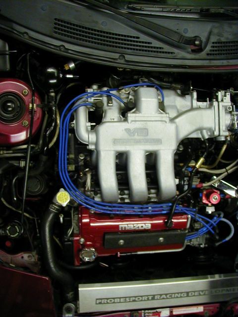1994 Ford Probe - Close-up of an engine bay a V6 intake manifold and a red valve cover with 'Mazda' branding.