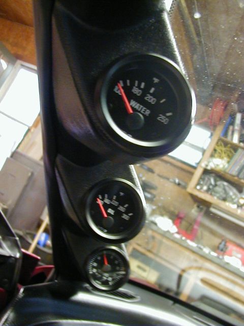 1994 Ford Probe - Close-up of aftermarket gauges installed in a vehicle's interior, showing water and oil temperature readings.