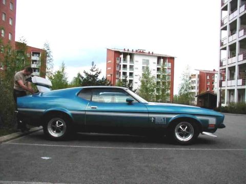 1972 Ford Mustang - Blue 1971 Ford Mustang Mach 1 parked in lot with a man loading the trunk.
