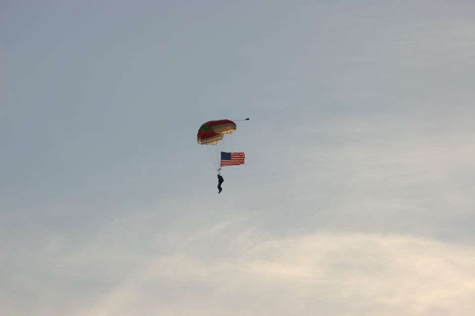 Skydiver descending with an American flag under a parachute