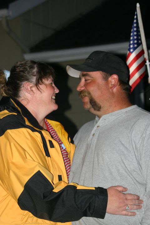 2003 Jeep TJ - A couple shares a moment with an American flag visible in the background.