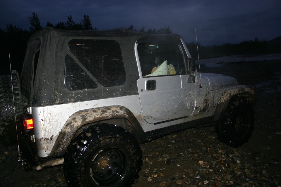 Silver 2003 Jeep TJ with soft top, covered in mud
