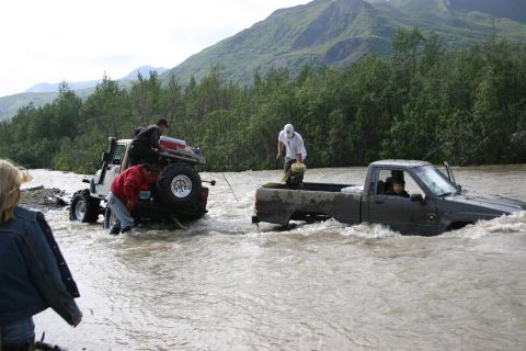 2003 Jeep TJ - A Jeep TJ is being assisted by a pickup truck while crossing a river.