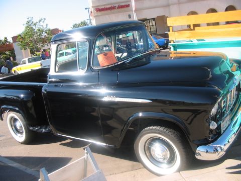 1986 Ford Bronco - A classic black pickup truck with chrome accents and whitewall tires is parked outdoors.