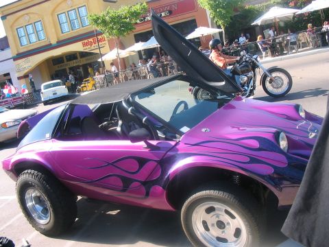 1986 Ford Bronco - A custom purple dune buggy with flame decals is parked on a street with a motorcycle in the background.