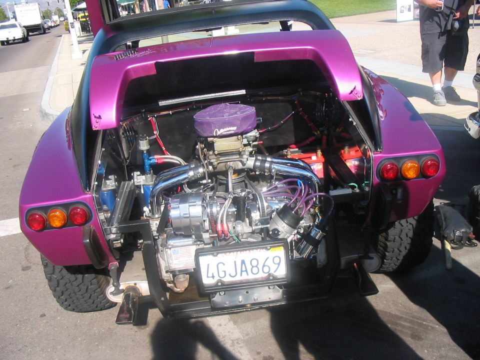 Purple custom car with exposed V8 engine, off-road tires, and a California license plate reading 4GJA869