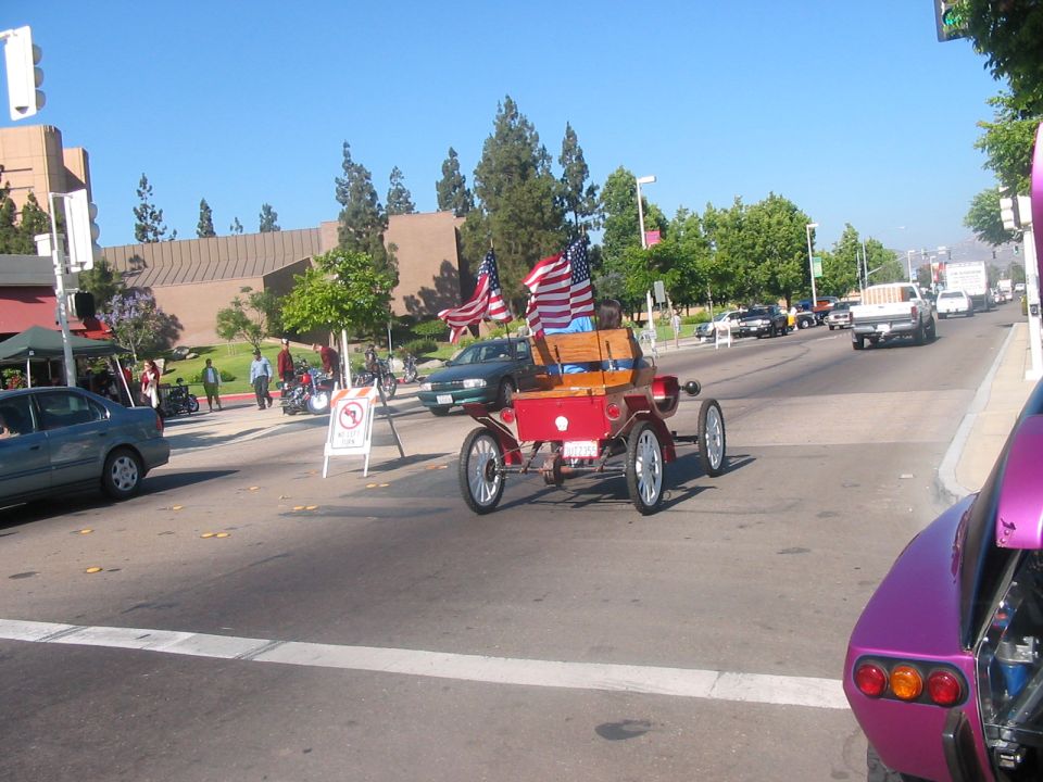 Antique red car with American flags, rear view