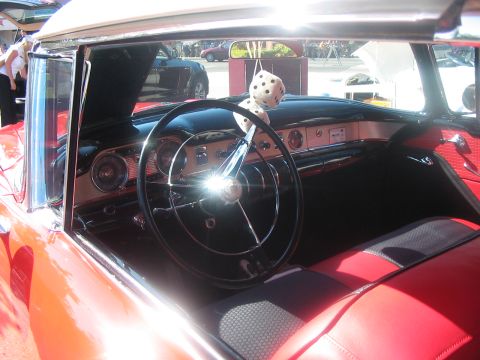 1986 Ford Bronco - The interior of a classic car features a large steering wheel and a dashboard with chrome accents.