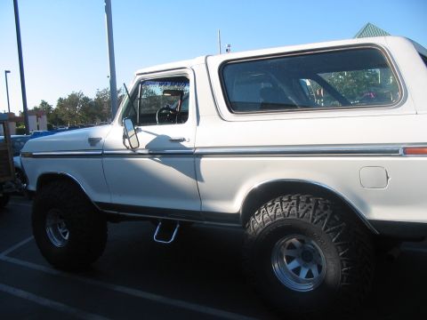 1986 Ford Bronco - This white SUV, likely from the late 1970s, is shown from the side, equipped with off-road tires.