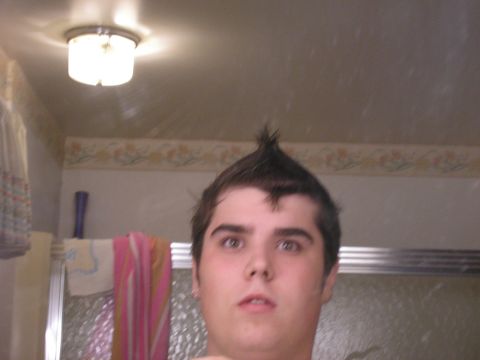 1990 Ford Probe - A person with a mohawk hairstyle looks into a mirror in a bathroom.