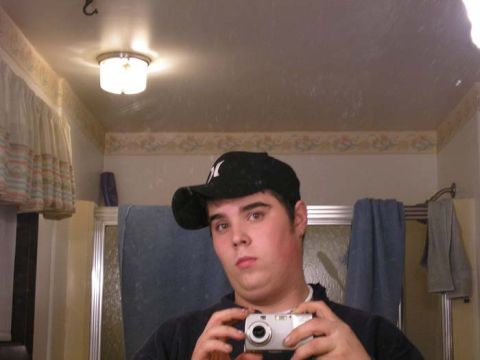 1990 Ford Probe - A man takes a selfie in a bathroom mirror while holding a digital camera.