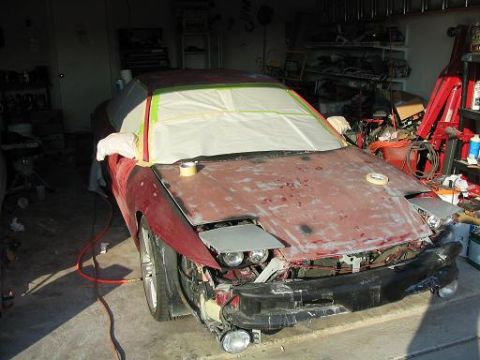 1994 Buick Park Avenue - A red car is in a garage, undergoing bodywork and preparation for painting.