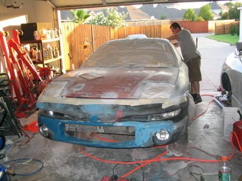 1994 Buick Park Avenue - A car is undergoing preparation for painting in a garage, with a person working on the hood.