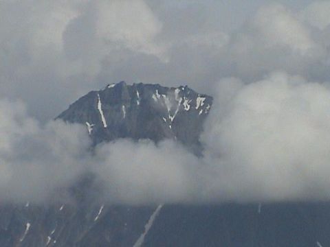 2000 Jeep Wrangler - A mountain peak emerges from the clouds, its slopes dusted with snow.