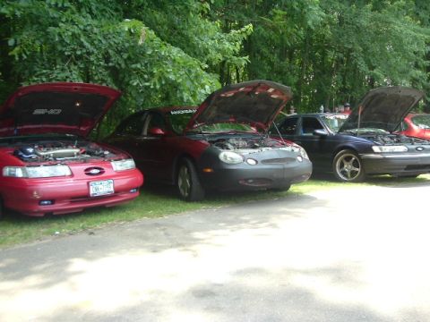 1993 Ford Taurus - Several Ford Taurus models are lined up with their engines exposed to view.