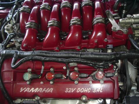 1993 Ford Taurus - Close-up view of a red Yamaha 32V DOHC 3.4L engine, highlighting the intake manifold and wiring harness.