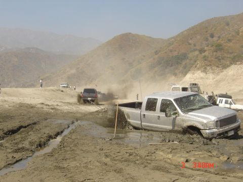 1977 Toyota Land Cruiser - Several trucks are stuck in the mud during an off-road event.