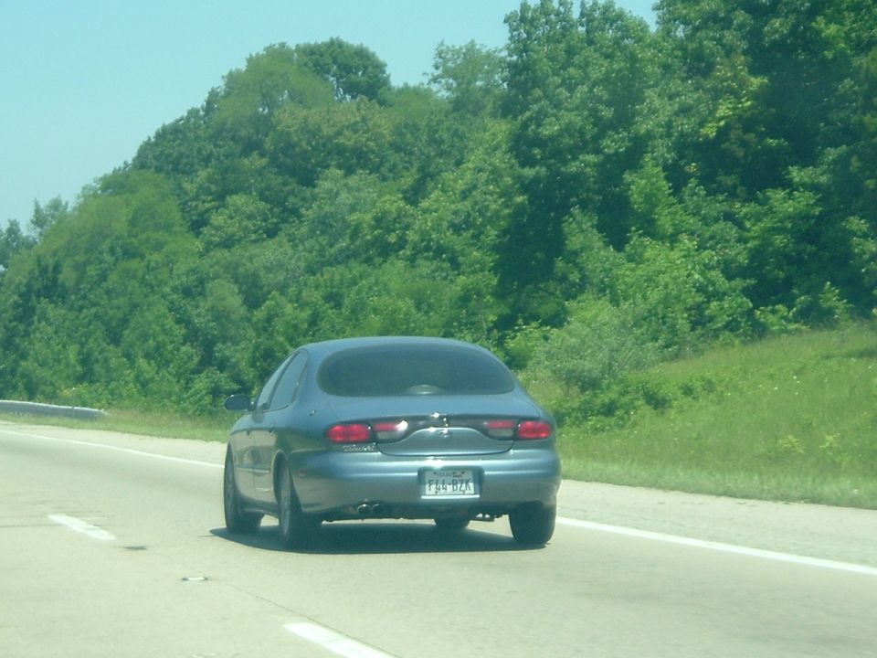 Blue sedan with a license plate F54-BZA driving on a highway