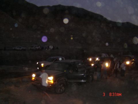 1977 Toyota Land Cruiser - Several vehicles and people are gathered outdoors at night, with headlights illuminating the scene.