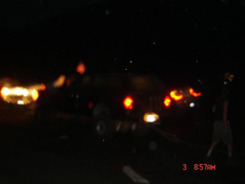 1977 Toyota Land Cruiser - Two vehicles are visible at night, with one showing illuminated brake lights.