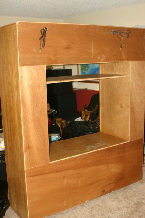 2003 Jeep TJ - A large wooden cabinet with an open central section and shelves is shown in a room.
