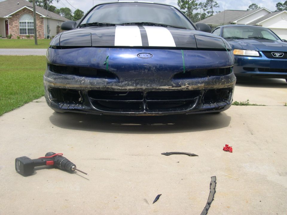 1997 Ford Probe front bumper removed, showing grille and headlights. Blue with white racing stripes