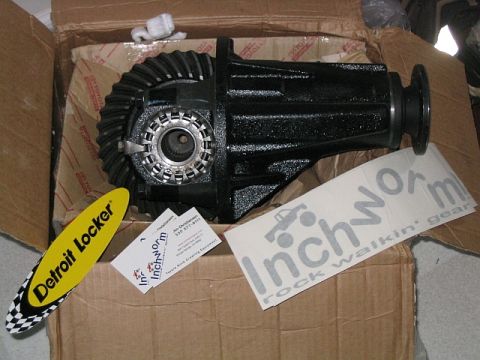 1986 Ford F-150 - A differential part is shown inside a cardboard box with various stickers from Inchworm and Detroit Locker.