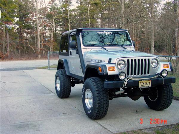 Lifted silver Jeep Wrangler Rubicon with snorkel and light bar