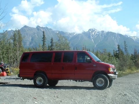 1994 Ford E350 - Red van parked on gravel with mountains behind it.