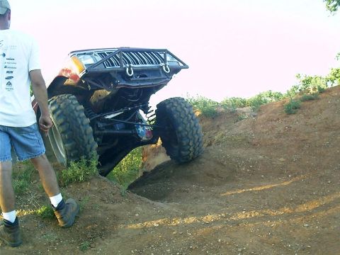 1986 Ford Bronco - This heavily modified off-road vehicle navigates a challenging dirt incline.