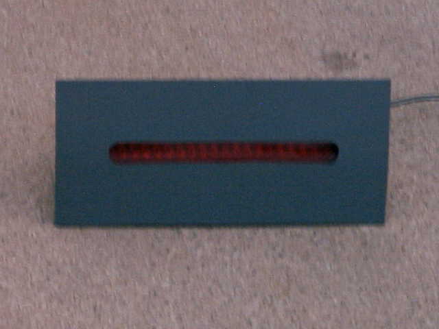 Rectangular gray panel with a slotted opening showing an unlit red LED strip