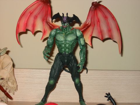 1991 Ford Bronco - A green demon action figure with large red wings stands next to a Yoda figure.