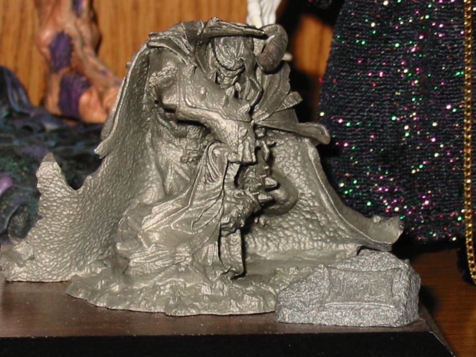 Close-up of a dark, detailed toy figure with a cape and horns