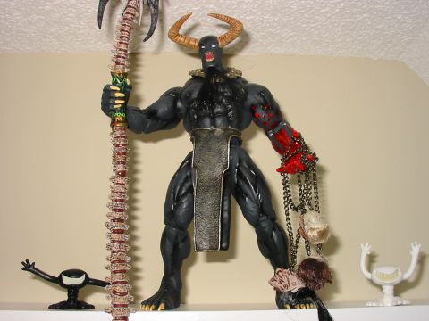 1991 Ford Bronco - Action figure with horns, staff, and chains with heads, displayed on a shelf.