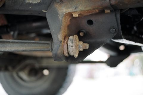 1979 Ford Bronco - A close-up view of a rusted suspension component on the underside of a vehicle, with a Supermotors.net logo visible.