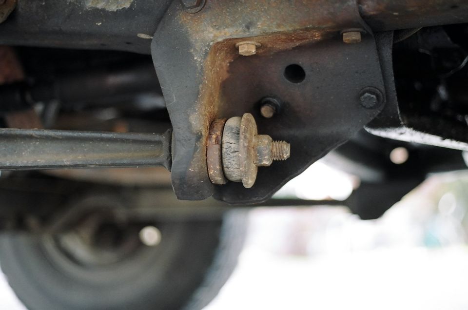 Undercarriage suspension part with rust and a Supermotors.net logo